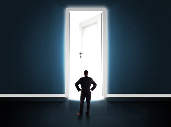 Zakenman kijkt naar grote heldere geopende deur — Stockfoto