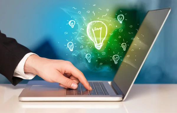 Close up of hand with laptop and  idea bulb — Stock Photo, Image