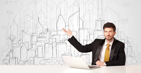 Businessman sitting at the white table with hand drawn buildings — Stock Photo, Image