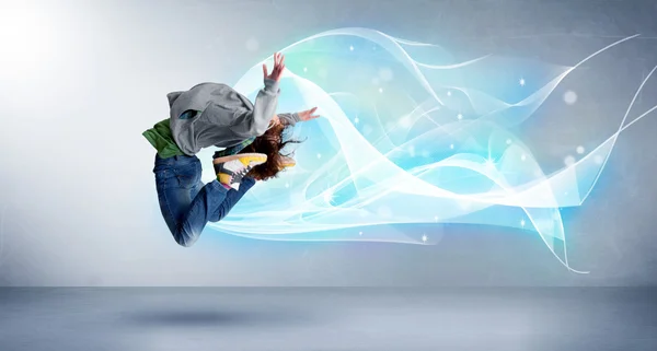 Cute teenager jumping with abstract blue scarf around her — Stock Photo, Image