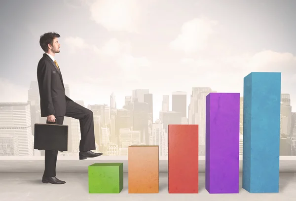 Business person climbing up on colourful chart pillars concept — Stock Photo, Image