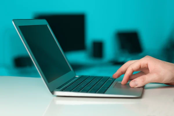 Empresário pressionando computador portátil moderno em backgrou colorido — Fotografia de Stock
