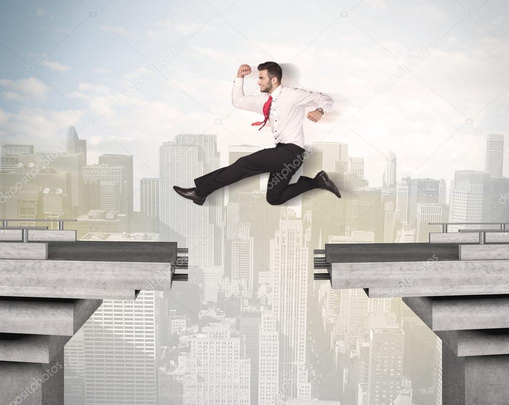 Energetic business man jumping over a bridge with gap