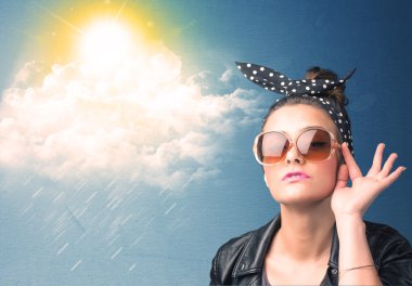 Güneş gözlükleriyle bulutlara ve güneşe bakan genç adam