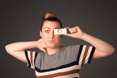 Elle çizilmiş göz küreleriyle kağıda bakan genç aptal kız.