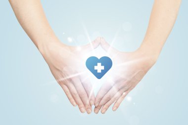 Eller mavi haçlı bir kalp yaratıyor.