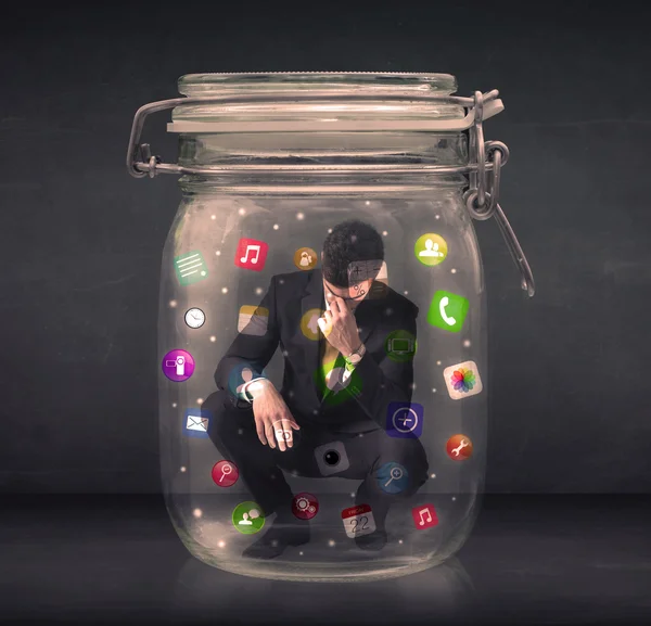 Businessman captured in a glass jar with colourful app icons con — Stock Photo, Image