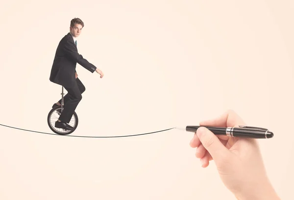 Businessman riding monocycle on a rope drawn by hand — Stock Photo, Image