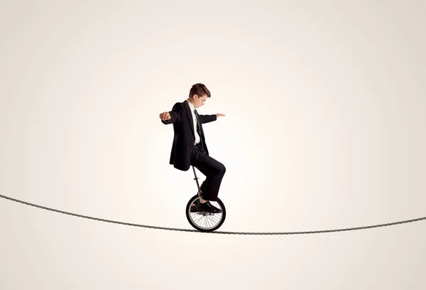 Hombre de negocios extremo montando monociclo en una cuerda — Foto de Stock