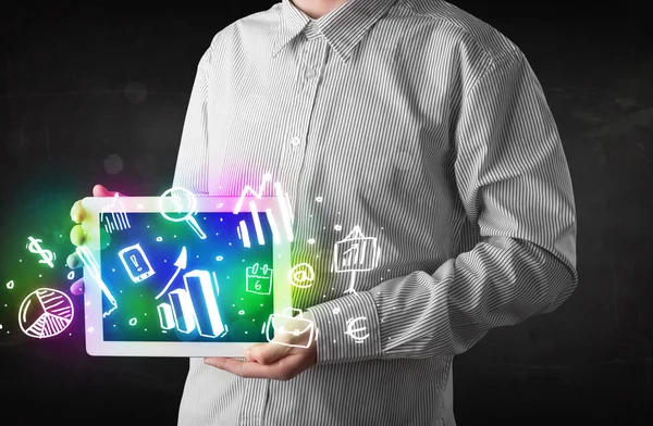 Young person holding tablet with graph and chart symbols — Stock Photo, Image