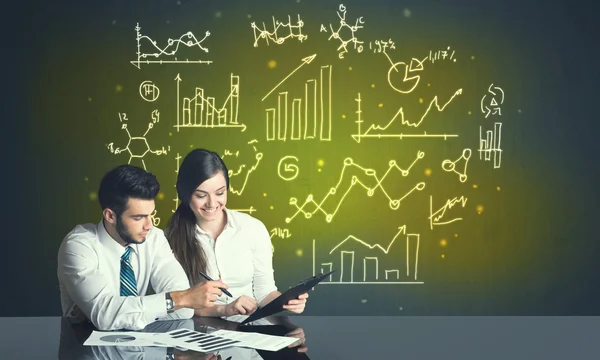 Business couple with business diagrams — Stock Photo, Image