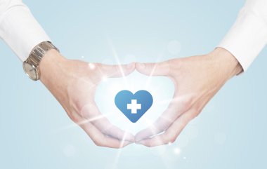 Eller mavi haçlı bir kalp yaratıyor.