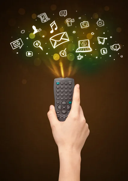 Hand with remote control and social media icons — Stock Photo, Image