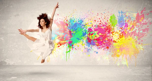 Happy teenager jumping with colorful ink splatter on urban backg — Stock Photo, Image