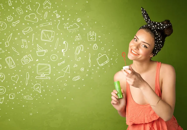 Cute girl blowing hand drawn media icons and symbols — Stock Photo, Image