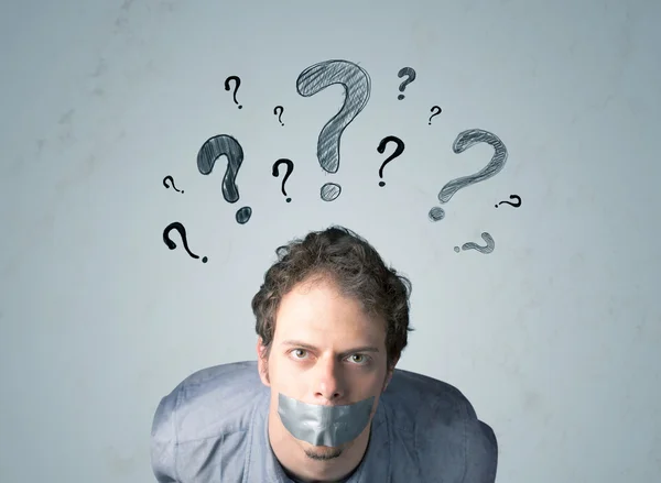 Young man with glued mouth and question mark symbols — Stock Photo, Image