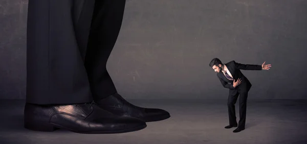 Pernas enormes com pequeno empresário em pé na frente conceito — Fotografia de Stock