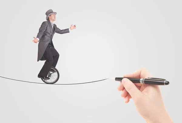 Zakenman rijden monocycle op een touw met de hand getrokken — Stockfoto