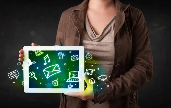 Person holding a tablet with media icons and symbols — Stock Photo, Image