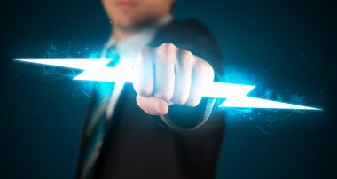 Business man holding glowing lightning bolt in his hands clipart