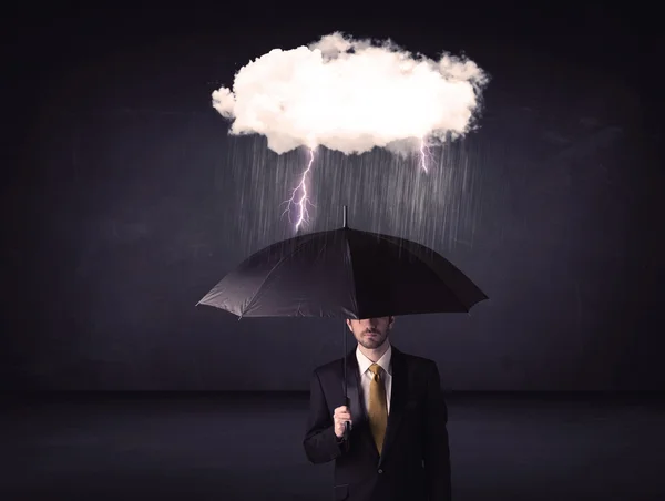 Empresario de pie con paraguas y pequeña nube de tormenta — Foto de Stock