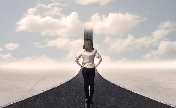 Business woman looking at road that goes up in the sky — Stock Photo, Image