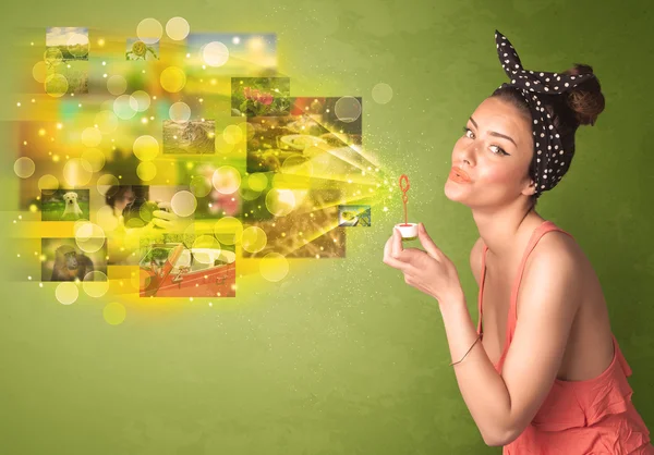 Cute girl blowing colourful glowing memory picture concept — Stock Photo, Image