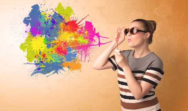 Cute girl blowing colorful splash graffiti — Stock Photo, Image