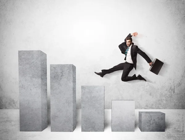 Successful business man jumping over charts on background — Stock Photo, Image