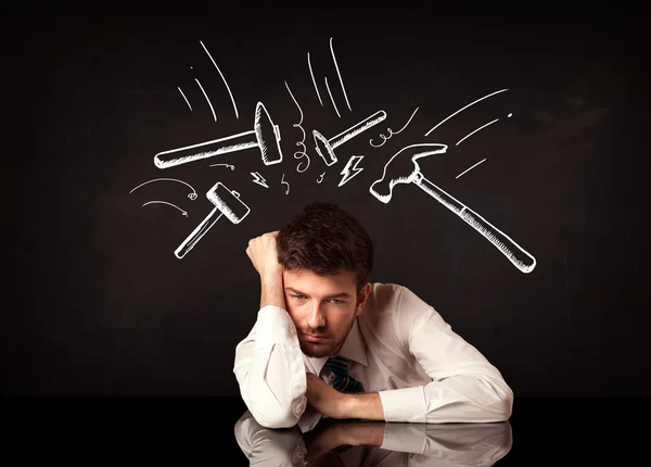 Depressiver Geschäftsmann sitzt unter Hammer — Stockfoto