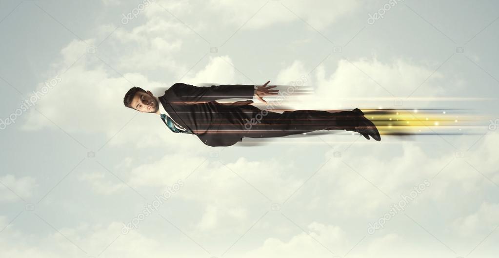 Happy business man flying fast on the sky between clouds