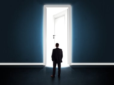 Büyük parlak kapıyı açan bir iş adamı.
