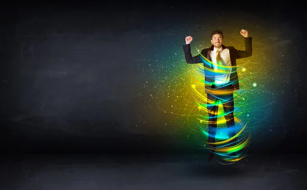 Excited business man jumping with energy colourful lines — Stock Photo, Image