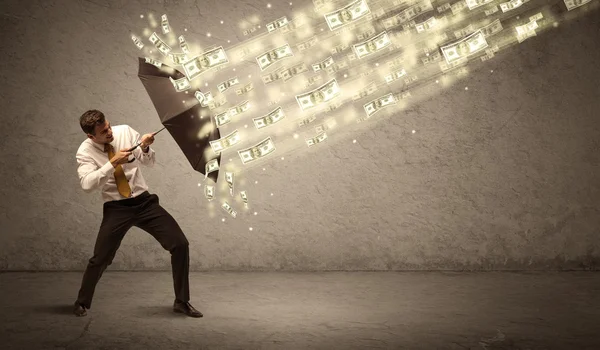 Hombre de negocios sosteniendo paraguas contra concepto de lluvia dólar —  Fotos de Stock