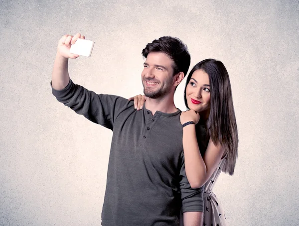 Mutlu çift temiz duvarlı selfie çekiyor.