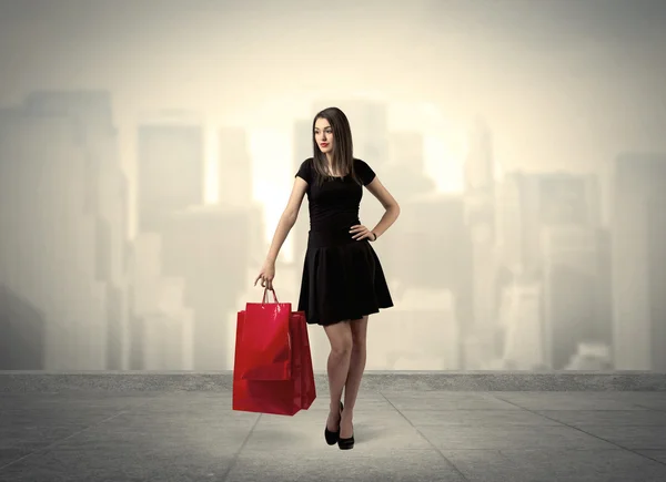 Элегантная городская девушка с красными сумками — стоковое фото
