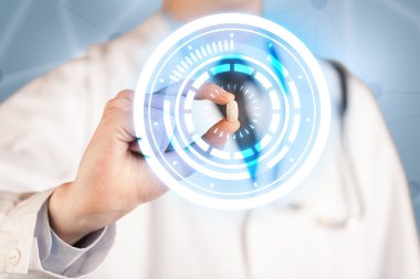 Erkek doktor elinde parlak halkaları olan bir hap tutuyor.
