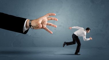 İş adamı büyük bir el kavramından kaçıyor.