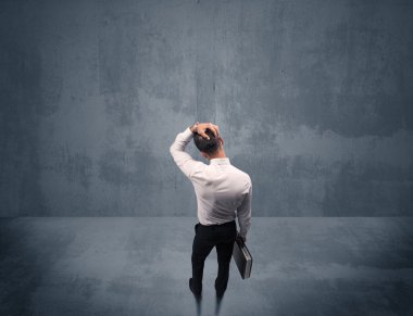 Şehir duvarının önünde duran iş adamı