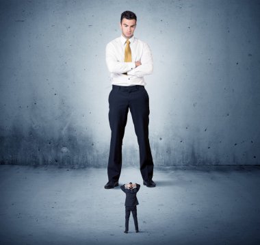 Öfkeli büyük iş adamı küçük adama lokma atıyor.