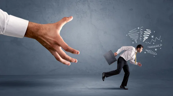 Stressful businessman running from a big hand — Stock Photo, Image