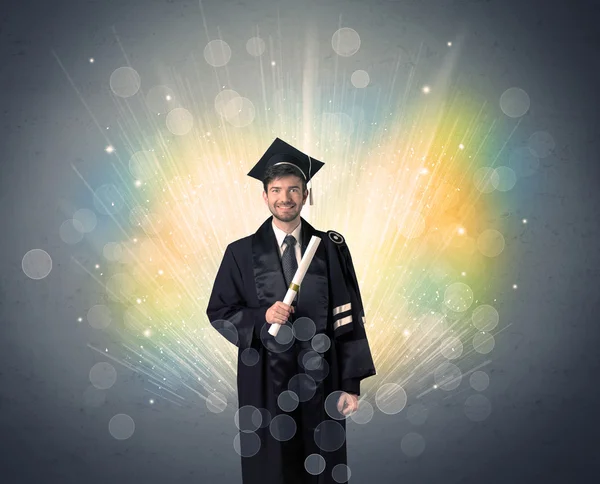 Feliz graduado con luces bokeg de colores en el fondo —  Fotos de Stock