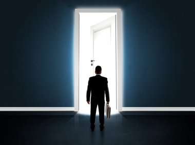 Büyük parlak kapıyı açan bir iş adamı.