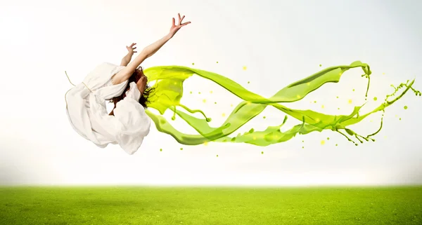Hezká dívka skákání se zelenou abstraktní tekuté šaty — Stock fotografie