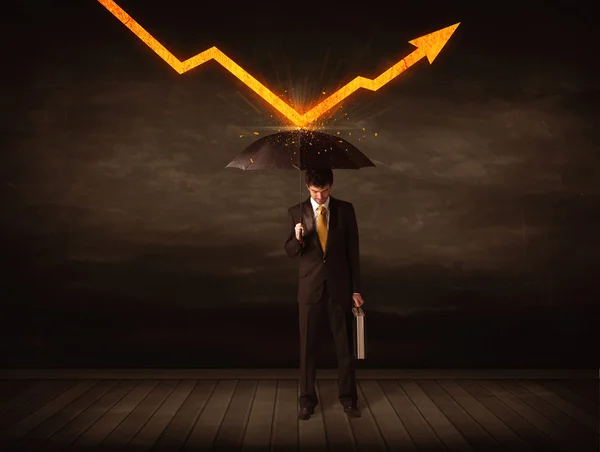 Businessman standing with umbrella keeping orange arrow — Stock Photo, Image