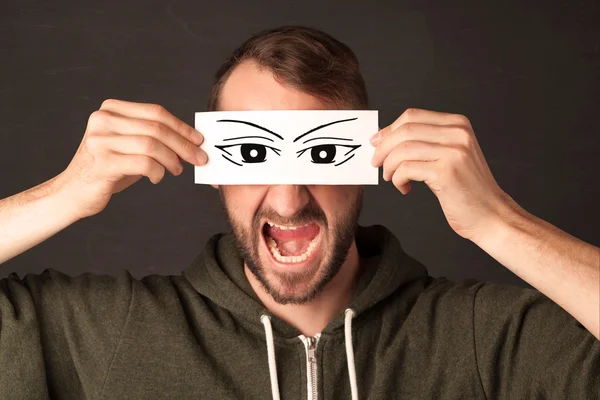Silly youngster looking with hand drawn eye paper — Stock Photo, Image