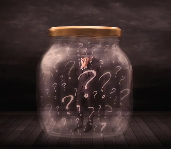 Businessman locked into a jar with question marks concept — Stock Photo, Image