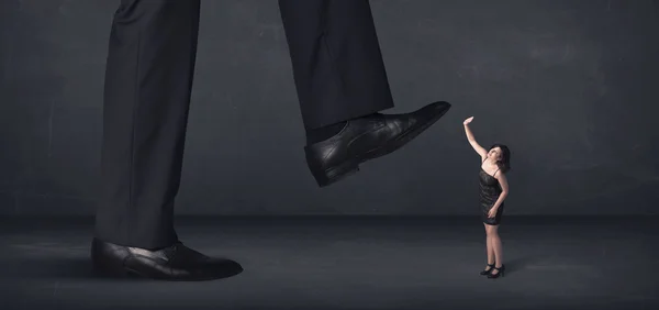 Giant person stepping on a little businesswoman concept — Stock Photo, Image