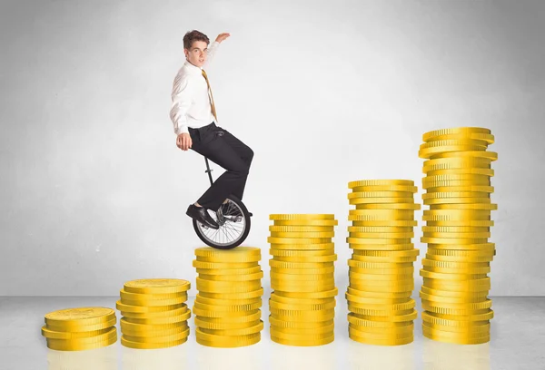 Forretningsmand ridning monocycle op på mønt graf - Stock-foto