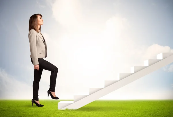 Business person climbing up on white staircase in nature Royalty Free Stock Images